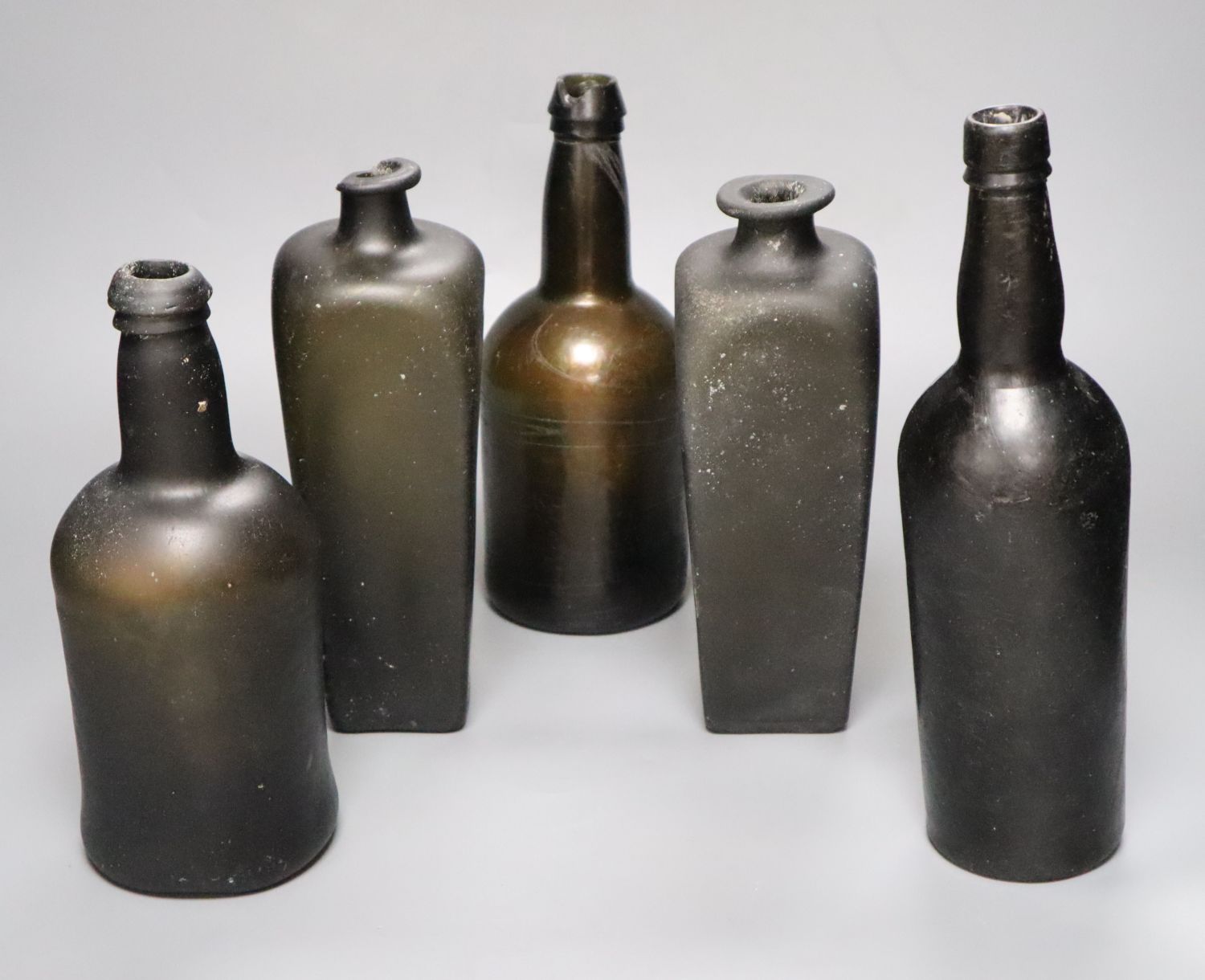 Five antique glass bottles, including two 18th century pig snout gin bottles,